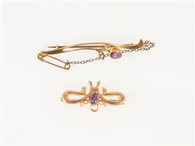 Lot 187 - Two amethyst brooches, a 55mm bar brooch set with an amethyst and four seed pearls, a 30mm brooch with single amethyst and hook to take a fob, both having metal pins.