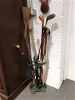 Lot 158 - A cast-iron stickstand with sticks, golf club, etc