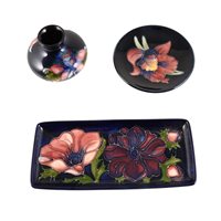 Lot 532 - Three items of Moorcroft Pottery, including an 'Orchid' design coaster, 'Anemone' tray, and another vase..