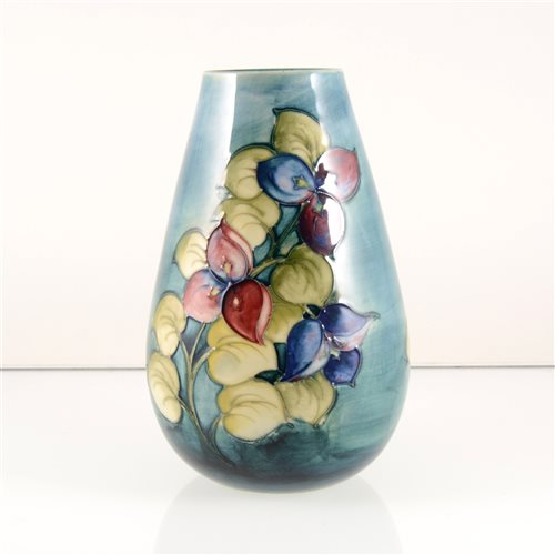 Lot 530 - A Moorcroft Pottery vase, designed by Walter Moorcroft, exotic flowers on a smokey blue ground.