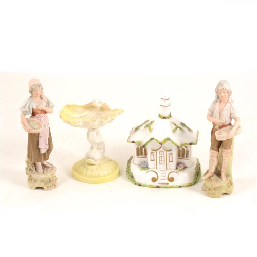 Lot 2 - A pair of Royal Dux figures - Fisher woman and man with baskets of fish, 16cm, a Royal Doulton dolphin and shell dish, 10cm, a Coalport cottage "The Gate House" (4)