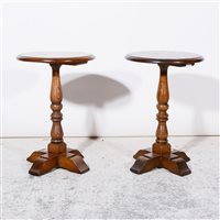 Lot 264 - A pair of "Old Charm" circular oak side/lamp tables, diameter 38cm, height 57cm,  turned column stem on four stpped feet, original label to underside of both.