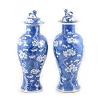 Lot 8 - Pair of Chinese blue and white covered vases, bearing four character marks, baluster shape, with domed lids, decorated with blossom, 34cm.