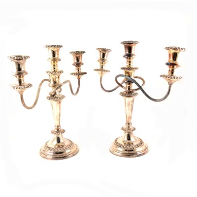 Lot 125 - A pair of electroplated candelabra, three sconce, round base and drip trays, separate into 7 pieces each, 32cm diameter, 33.5cm high.