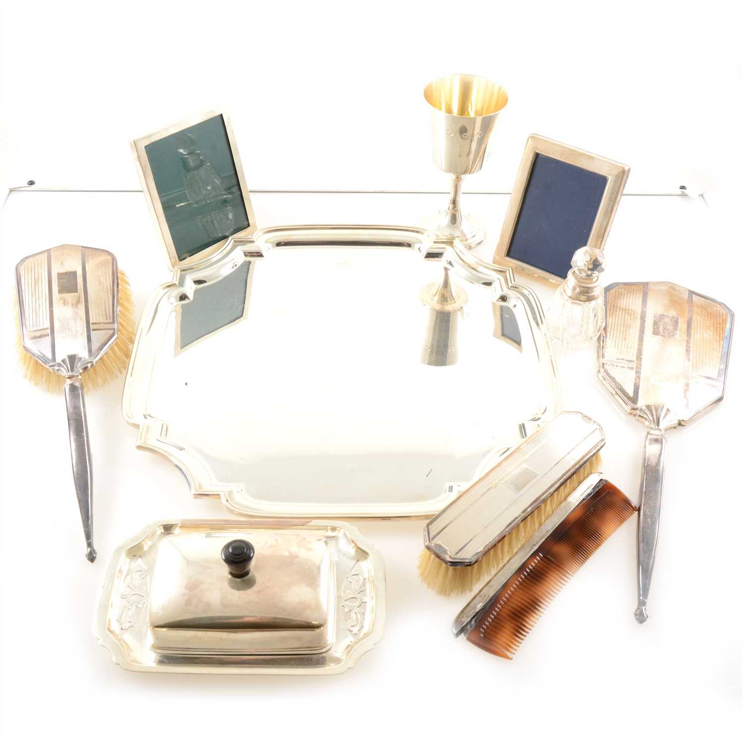 Lot 223 - A silver backed dressing table set, silver jubilee goblet 1977 , two photograph frames - one silver, one plated, silver topped smelling salts bottle and plated salver.