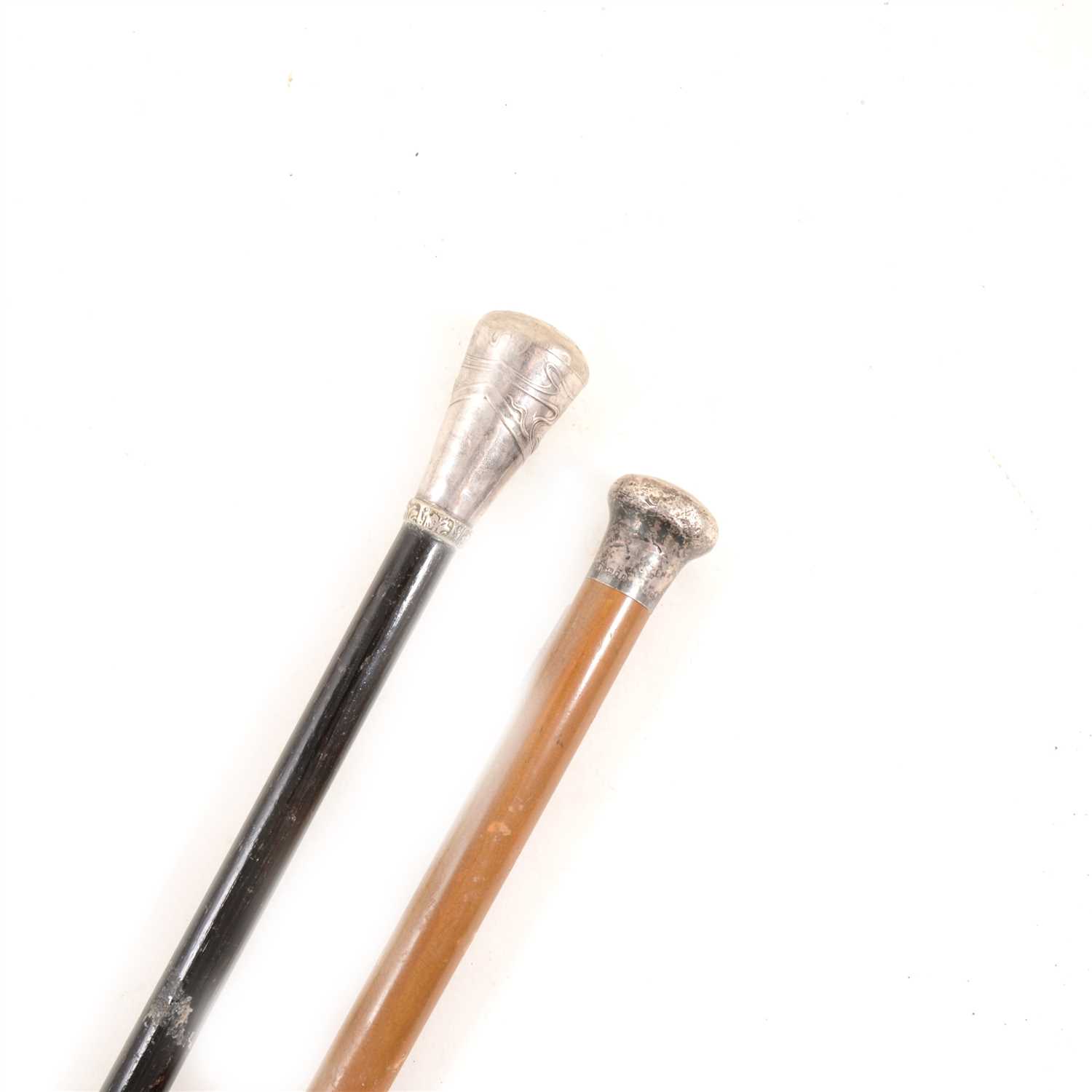 Lot 135 - Two walking canes, one with a hallmarked silver pommel, London 1924, the other with an Art Nouveau-style metal pommel.