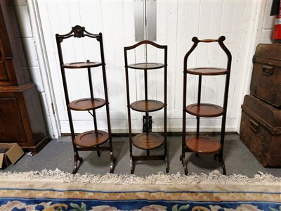 Lot 461 - One oak and two mahogany folding three tier cake stands, a middle eastern folding table base with a replacement mahogany circular tray top.