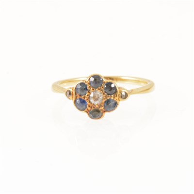 Lot 254 - A sapphire and diamond ring, six sapphires and three rose cut diamonds set as a small circular cluster in an all yellow metal mount, ring size J.