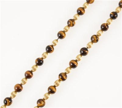 Lot 277 - A yellow metal and tigers eye bead necklace, forty 9.5mm tigers eye beads