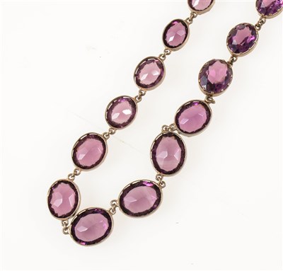 Lot 281 - An amethyst coloured paste necklace, twenty-four oval mixed cut stones