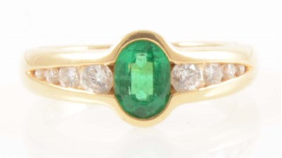 Lot 208 - An 18 carat yellow gold ring set with an emerald and eight diamonds.