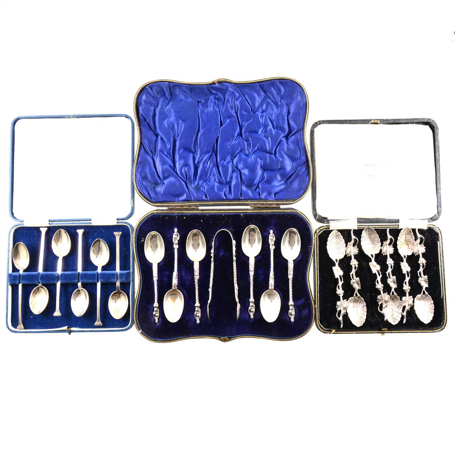 Lot 207 - A cased set of six silver teaspoons with apostle finials and a pair of sugar tongs by William Hutton & Sons Ltd, London 1902, a cased set of six silver coffee spoons with elaborate foliage design