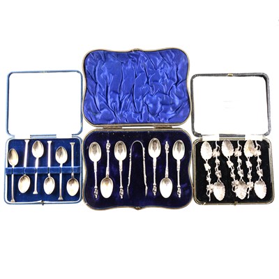 Lot 207 - A cased set of six silver teaspoons with apostle finials and a pair of sugar tongs by William Hutton & Sons Ltd, London 1902, a cased set of six silver coffee spoons with elaborate foliage design