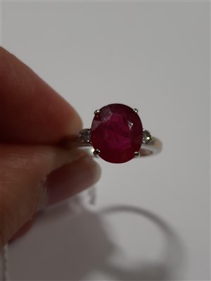 Lot 203 - A ruby and diamond three stone ring, an oval mixed cut ruby