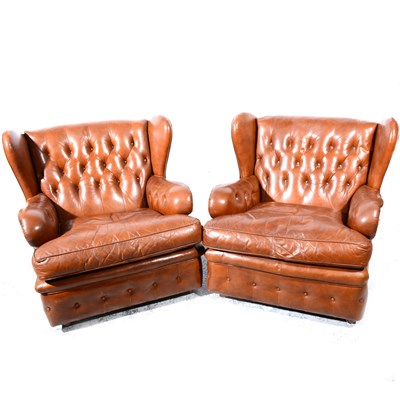Lot 366 - A pair of tan buttoned leather wing-back easychairs