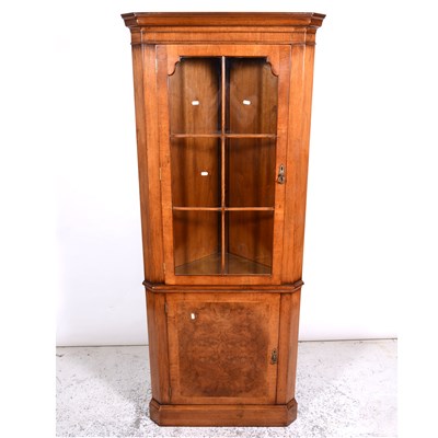 Lot 302 - Reproduction walnut corner cabinet, moulded cornice, plain frieze, the upper section glazed enclosed door enclosing shelves, cupboard below, plinth base, width 80cm, height 187cm.