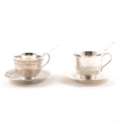 Lot 318 - Middle-Eastern white metal cup and saucer, probably Turkish, embossed and engraved decoration, unmarked; together with a similar white metal cup and saucer, each designed with an engraved band.