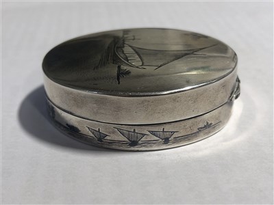Lot 239 - A white metal patch box with mirror depicting a niello sailing junk, 50mm, and another 25mm pill box with engine turned cover, Birmingham 1918.