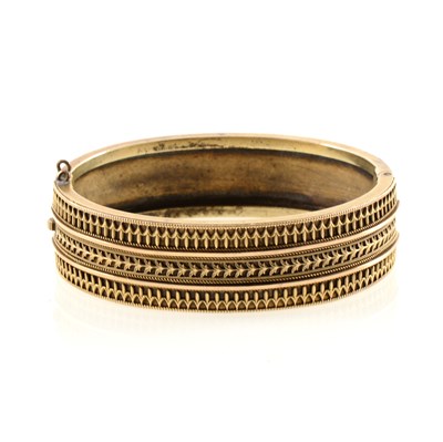 Lot 213 - A yellow metal bangle in the Etruscan style.