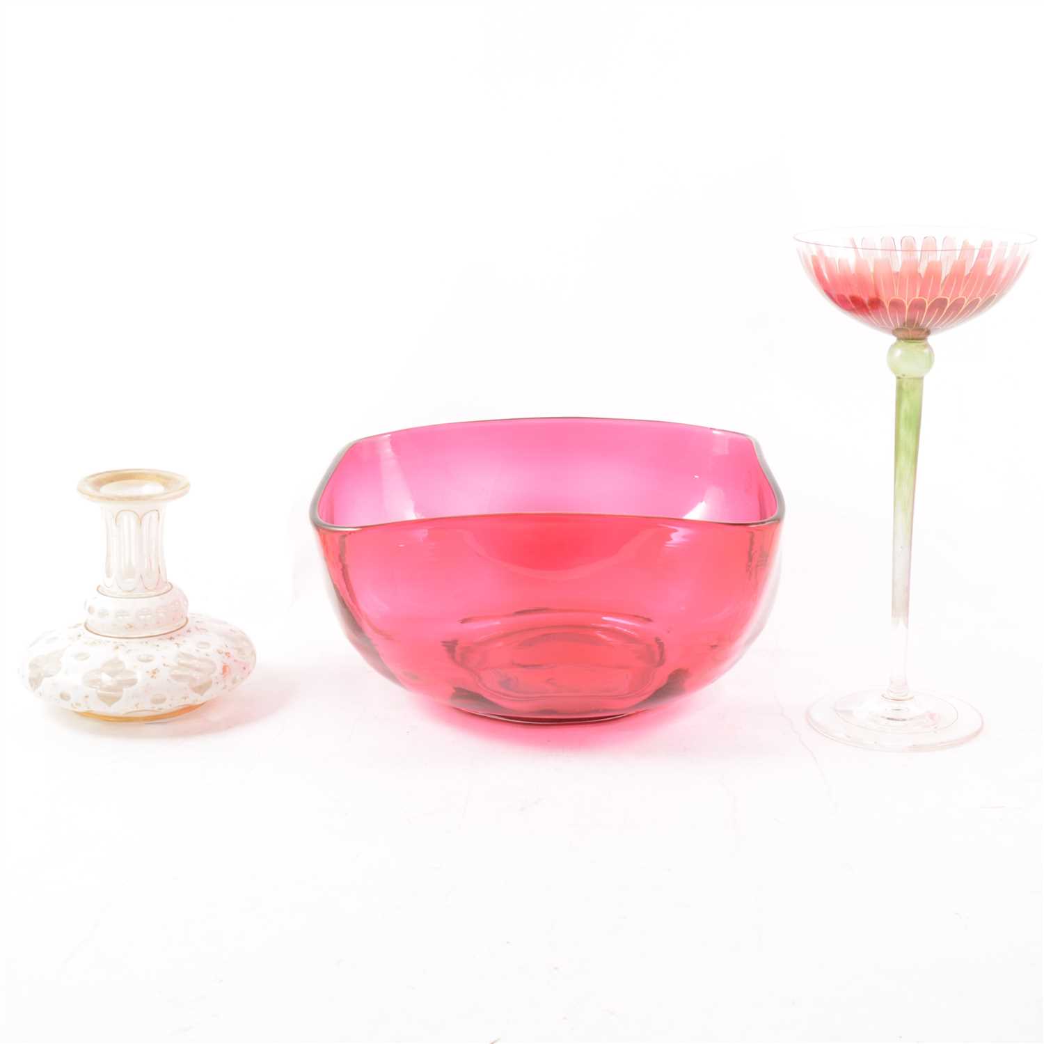 Lot 51 - A cranberry glass dish, square with curved corners, a small white overlaid glass vase, faded gilded decoration, and an Art Deco tall hand painted glass