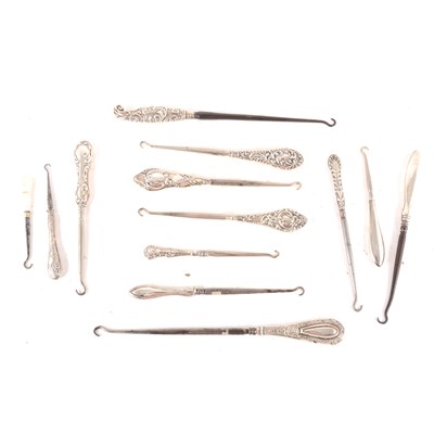 Lot 195 - A collection of Victorian and later button hooks with embossed silver shafts, plus a Victorian horseshoe shaped silver vesta case.