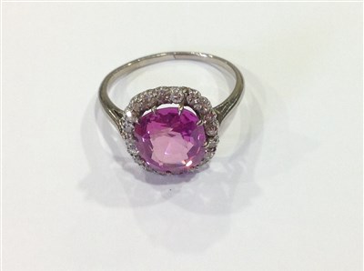 Lot 197 - A pink sapphire and diamond cluster ring.