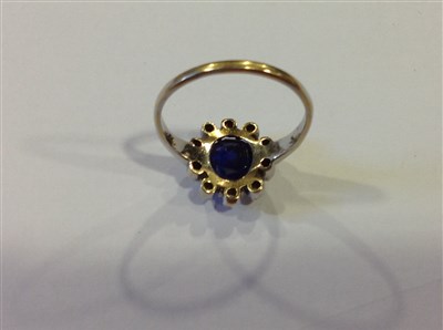 Lot 198 - A sapphire and diamond cluster ring.