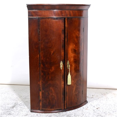 Lot 363 - A George III mahogany bowfront hanging corner cupboard