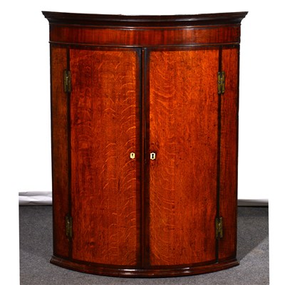 Lot 383 - A George III oak and mahogany cylinder front hanging corner cupboard