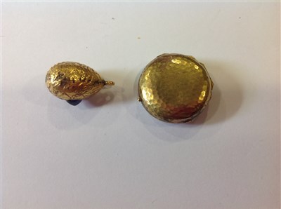 Lot 266 - A yellow metal circular locket and egg pendant.