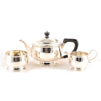 Lot 242 - A silver three-piece teaset by Goldsmiths & Silversmiths Co. and associated sugar tongs