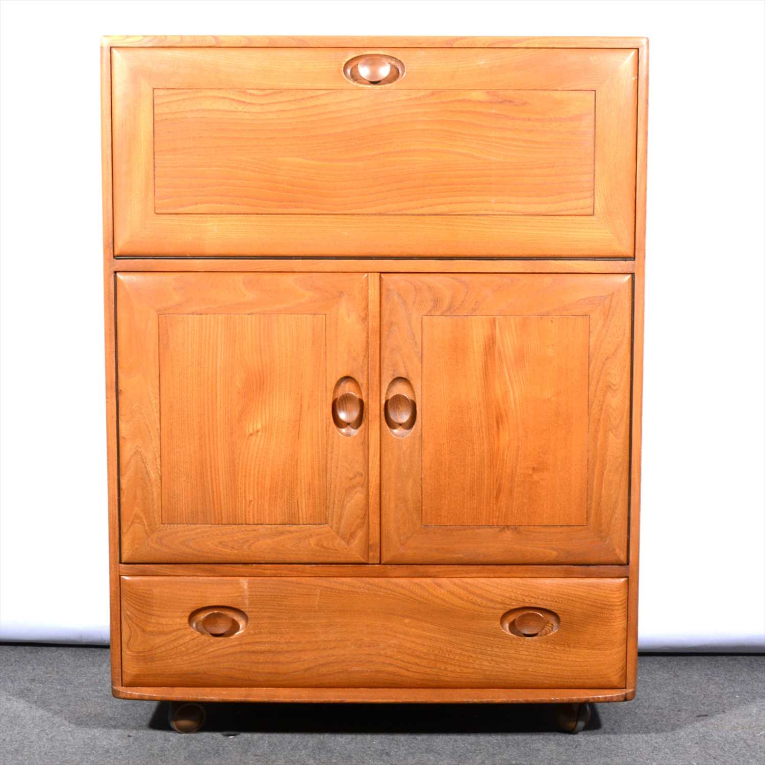 Lot 260 - A light elm serving cabinet by Ercol