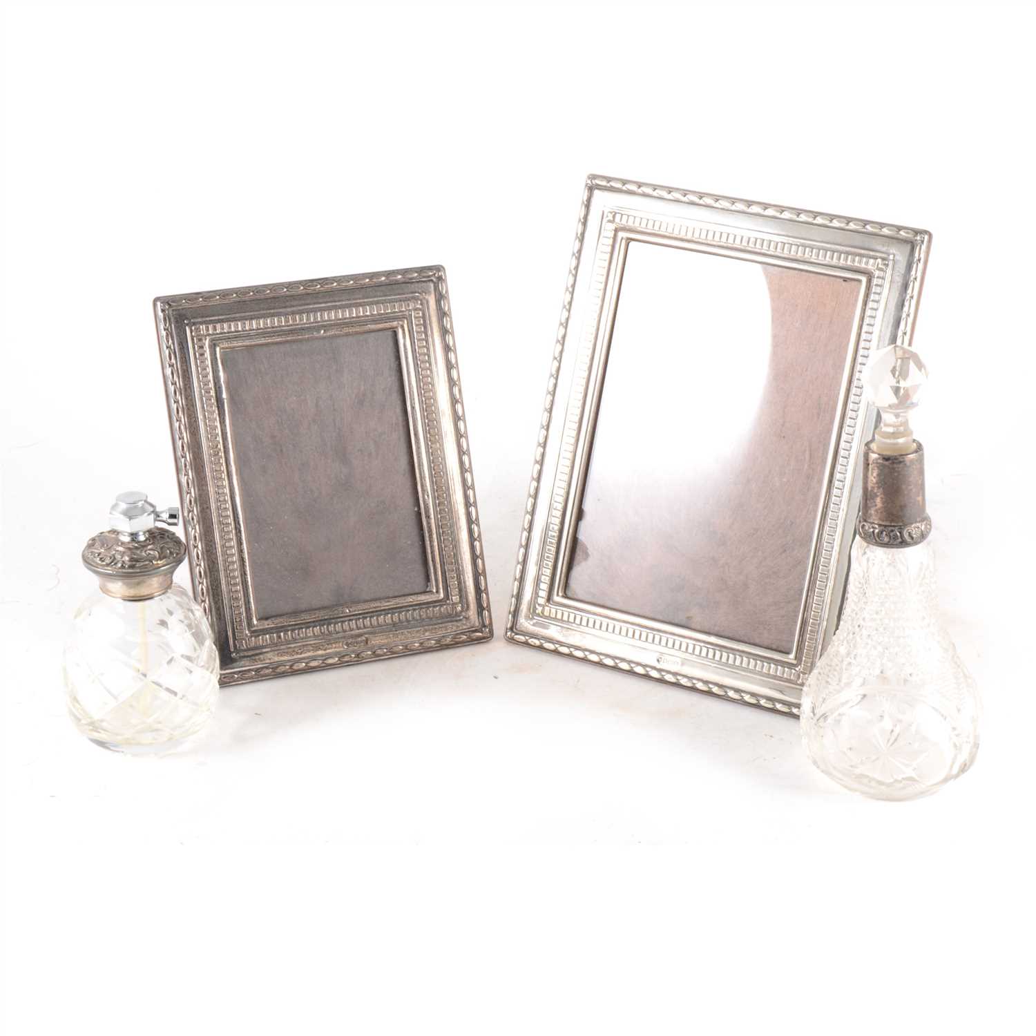 Lot 246 - Two silver photograph frames, silver topped scent bottle and silver topped atomiser.