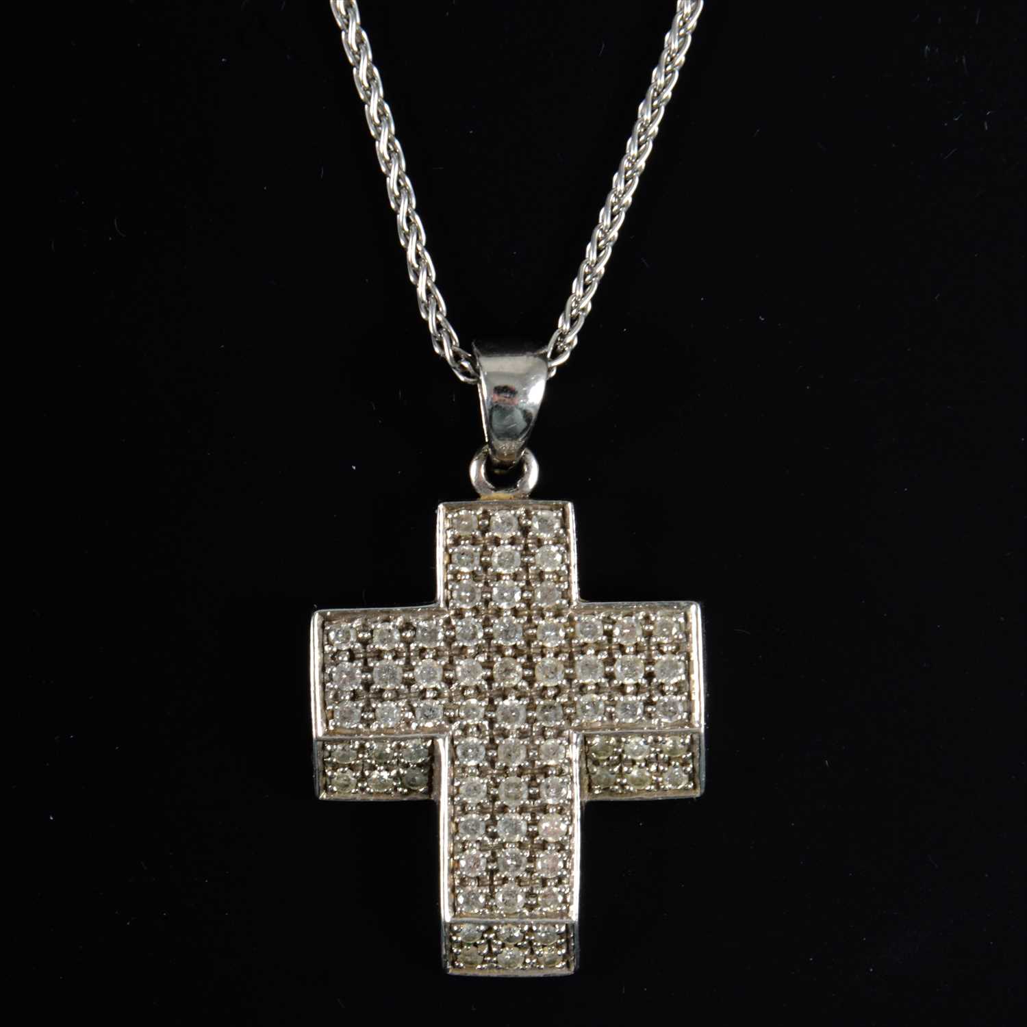 Lot 686 - A diamond set cross and chain.