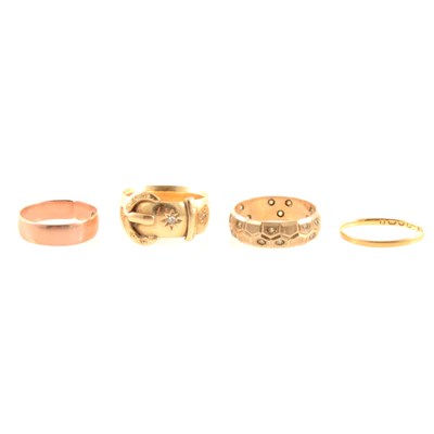 Lot 292 - Four gold rings, including an 18 carat yellow gold 7mm wide buckle ring set with two diamond points