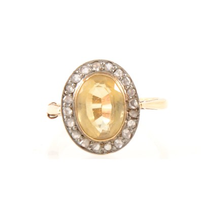 Lot 278 - A citrine and diamond oval cluster ring.