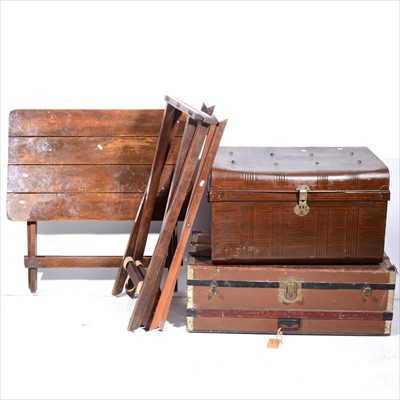 Lot 451 - A stained oak folding garden table, two luggafe stands, and two old trunks