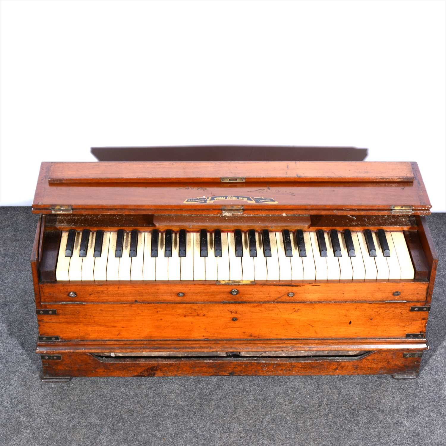 Lot 137 - A walnut and brass banded folding harmonium/ ship's piano