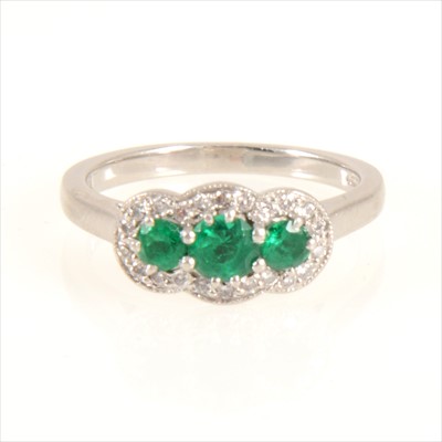 Lot 673 - An emerald and diamond cluster ring.