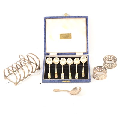Lot 153 - A set of six silver and enamelled coffee spoons, toast-rack, Georgian caddy spoon and napkin rings.