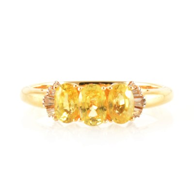 Lot 208 - A three stone yellow sapphire ring with diamond shoulders.