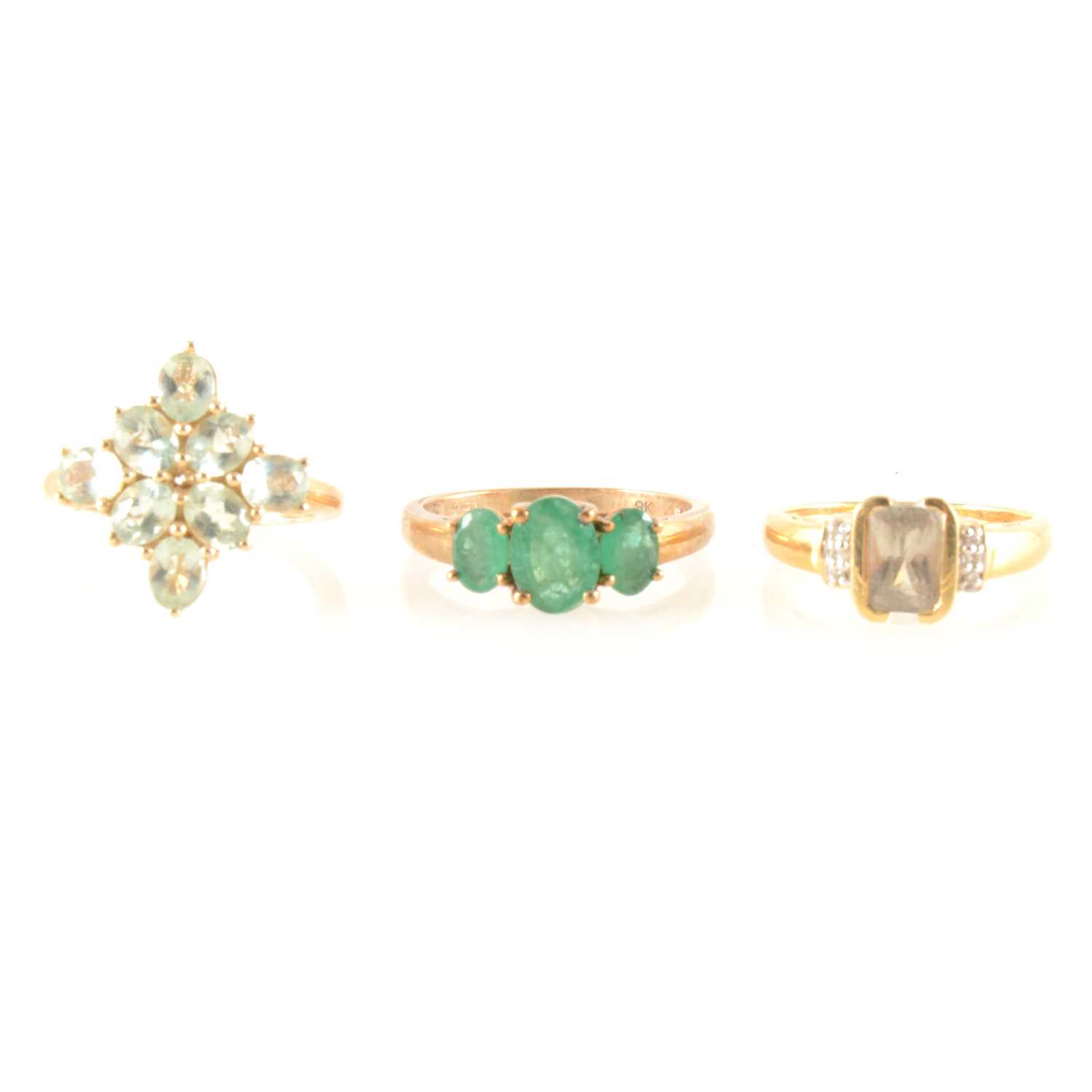 Lot 220 - Three dress rings, an emerald three stone ring, amblygonite cluster ring, zultanite and diamond ring.