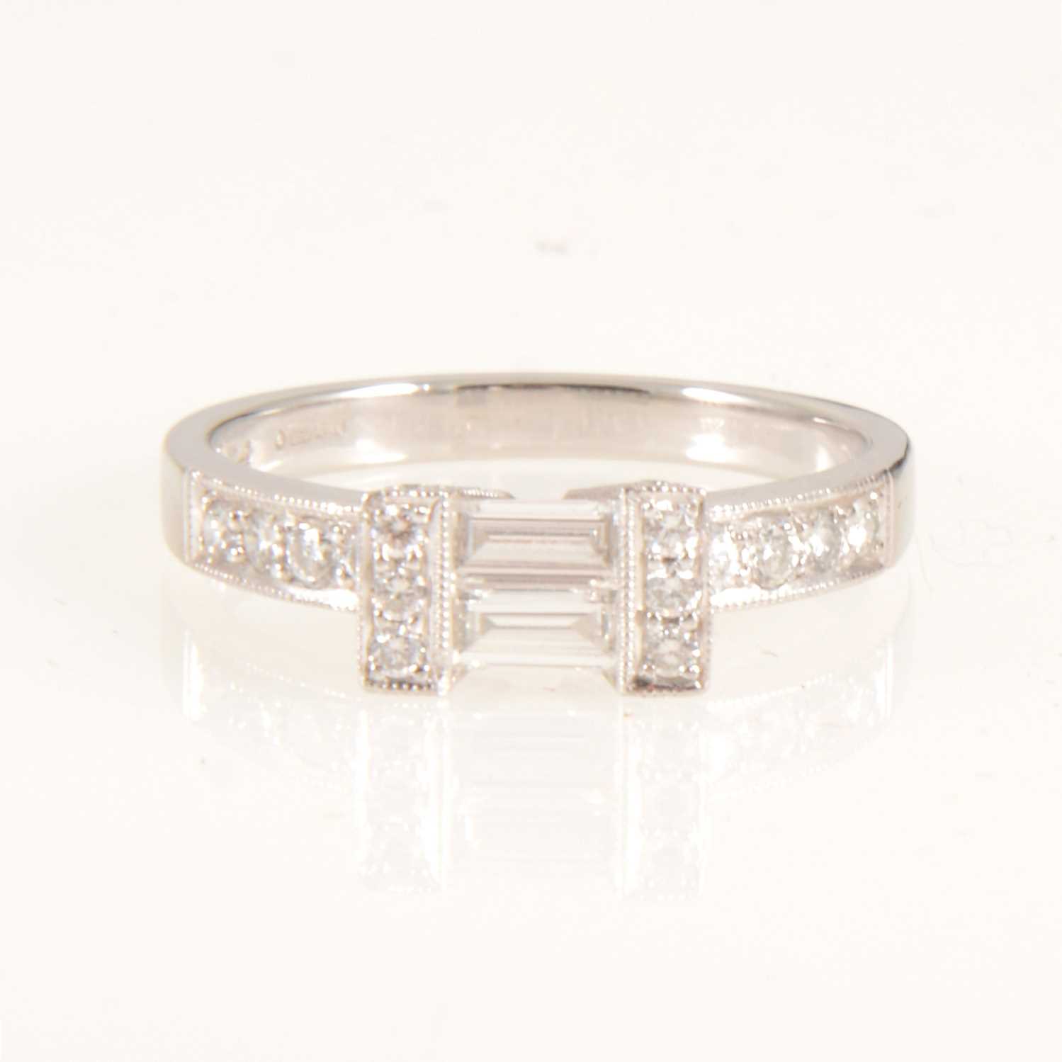 Lot 661 - A diamond baguette cut ring with brilliant cut shoulders.