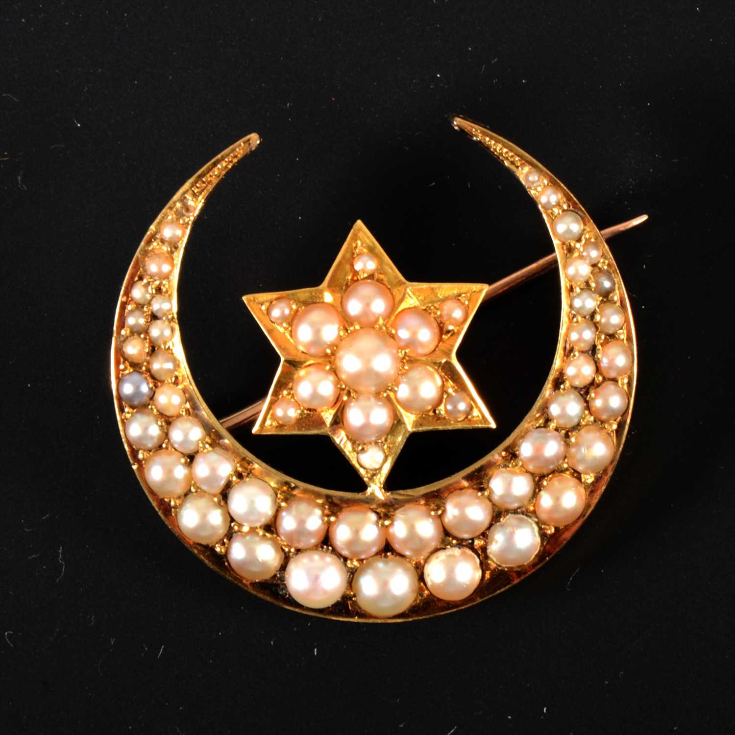 Lot 651 - A seed pearl closed crescent brooch with star motif.