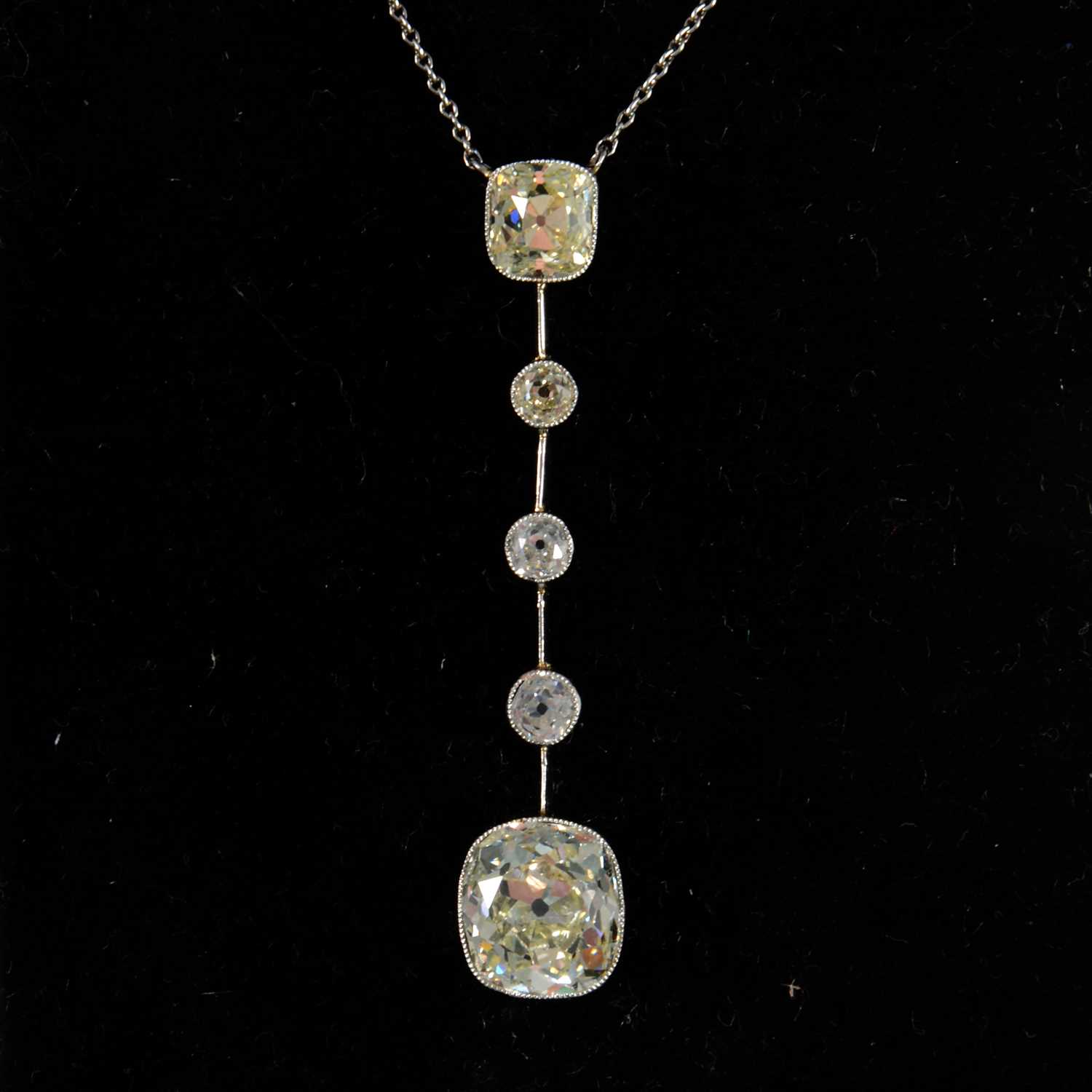 Lot 684 - A diamond set drop pendant with two antique cushion cut diamonds and three old cut diamonds.