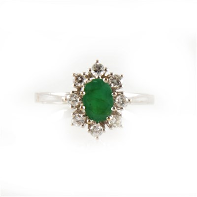 Lot 217 - An emerald and diamond oval cluster ring.