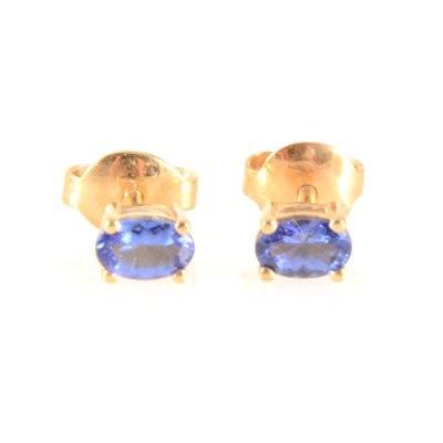 Lot 164 - A pair of tanzanite solitaire earrings.