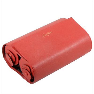 Lot 711 - Cartier - a red leather leather double roll with fabric interior to hold watches, Cartier Paris tooled in red on the exterior, 21.5cm wide.