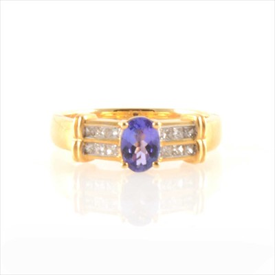 Lot 294 - An oval tanzanite ring with diamond shoulders.
