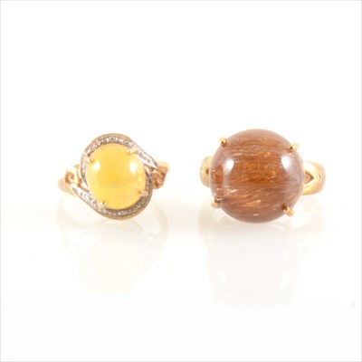 Lot 254 - An opal ring and a brown stone ring.